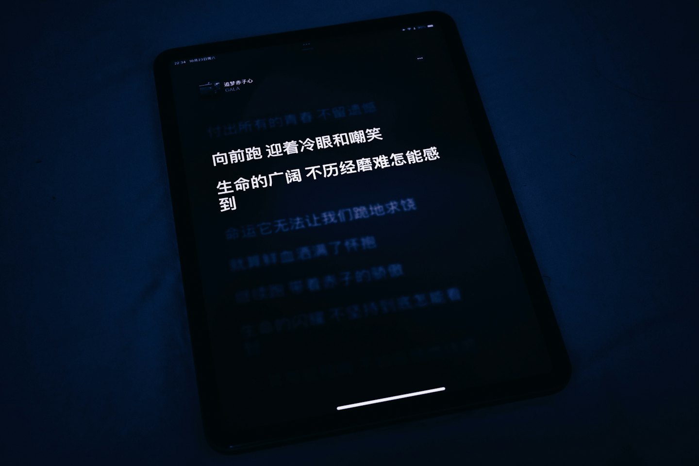 Digital tablet screen displaying Chinese text in a dark room.